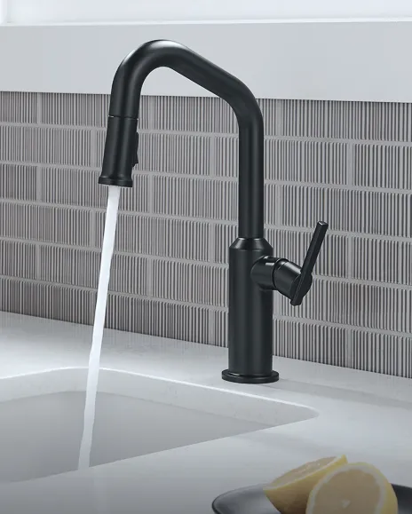 Delta Cordova pull-down faucet in matte black pouring water into white sink with vertical pattern tile backsplash