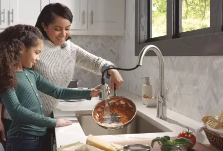 mother and daughter washing a dish