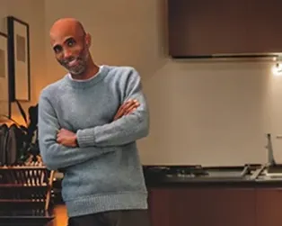 Smiling man leans against his kitchen counter. Overlay show Delta USA Today Most Trusted Brands 2026.
