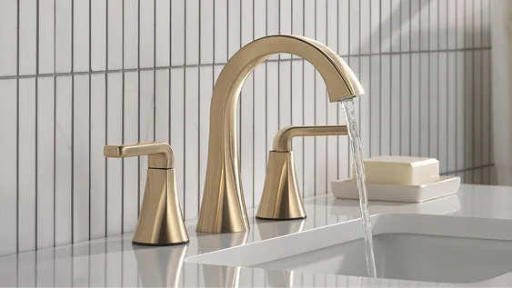 Delta bathroom Lineax 2-handle faucet in champagne bronze on off-white quartz bathroom counter pouring water into bathroom sink.